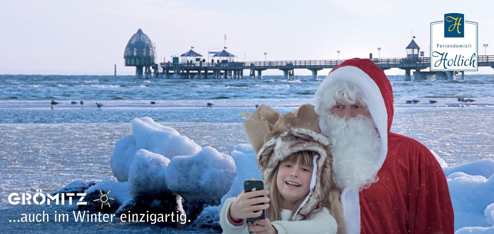 Weihnachtsmann und Mädchen schießen ein Selfie vor der Grömitzer Seebrücke