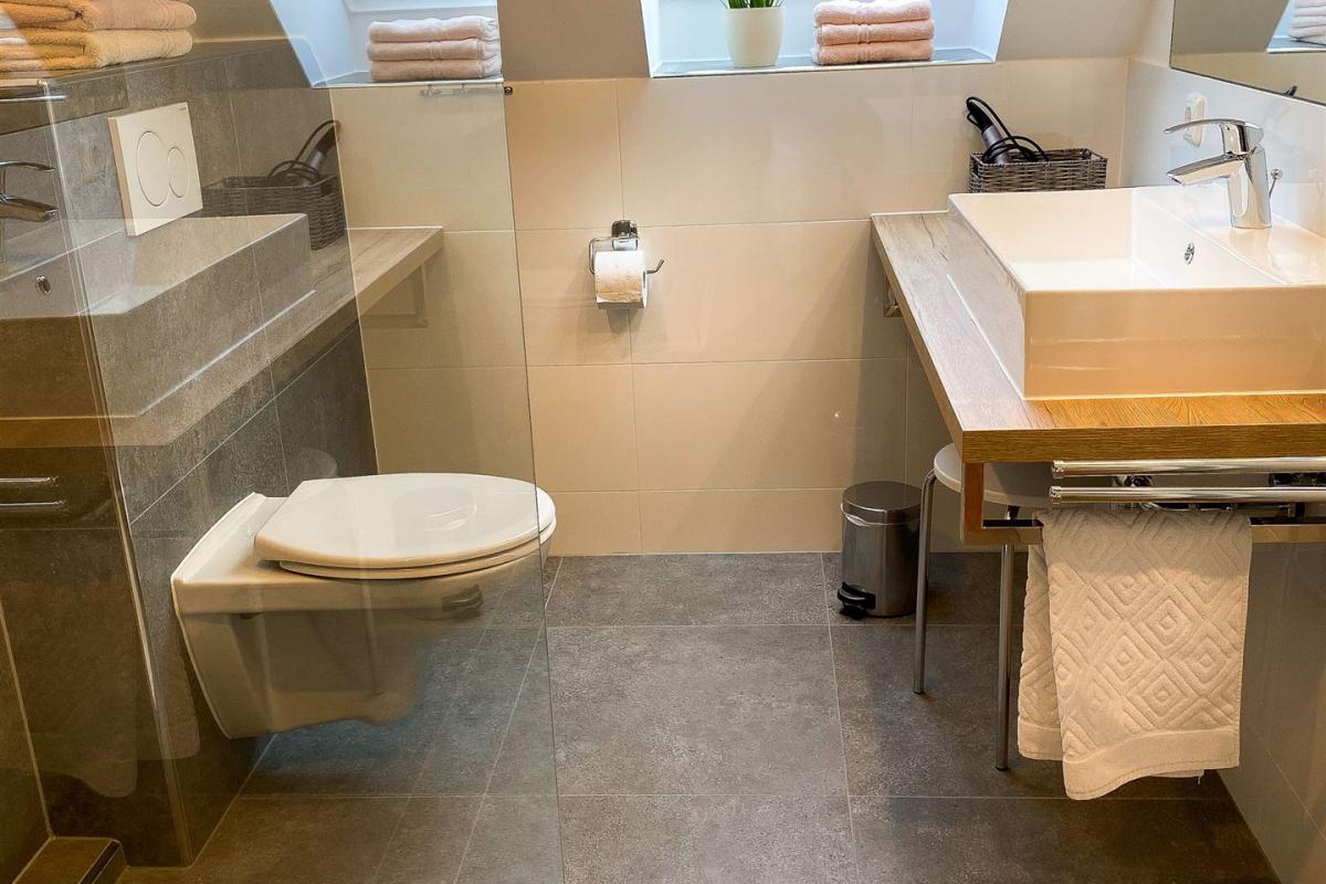 Wertig eingerichtetes Duschbad mit modernen Elementen: Dusche, WC und Konsolen-Waschtisch