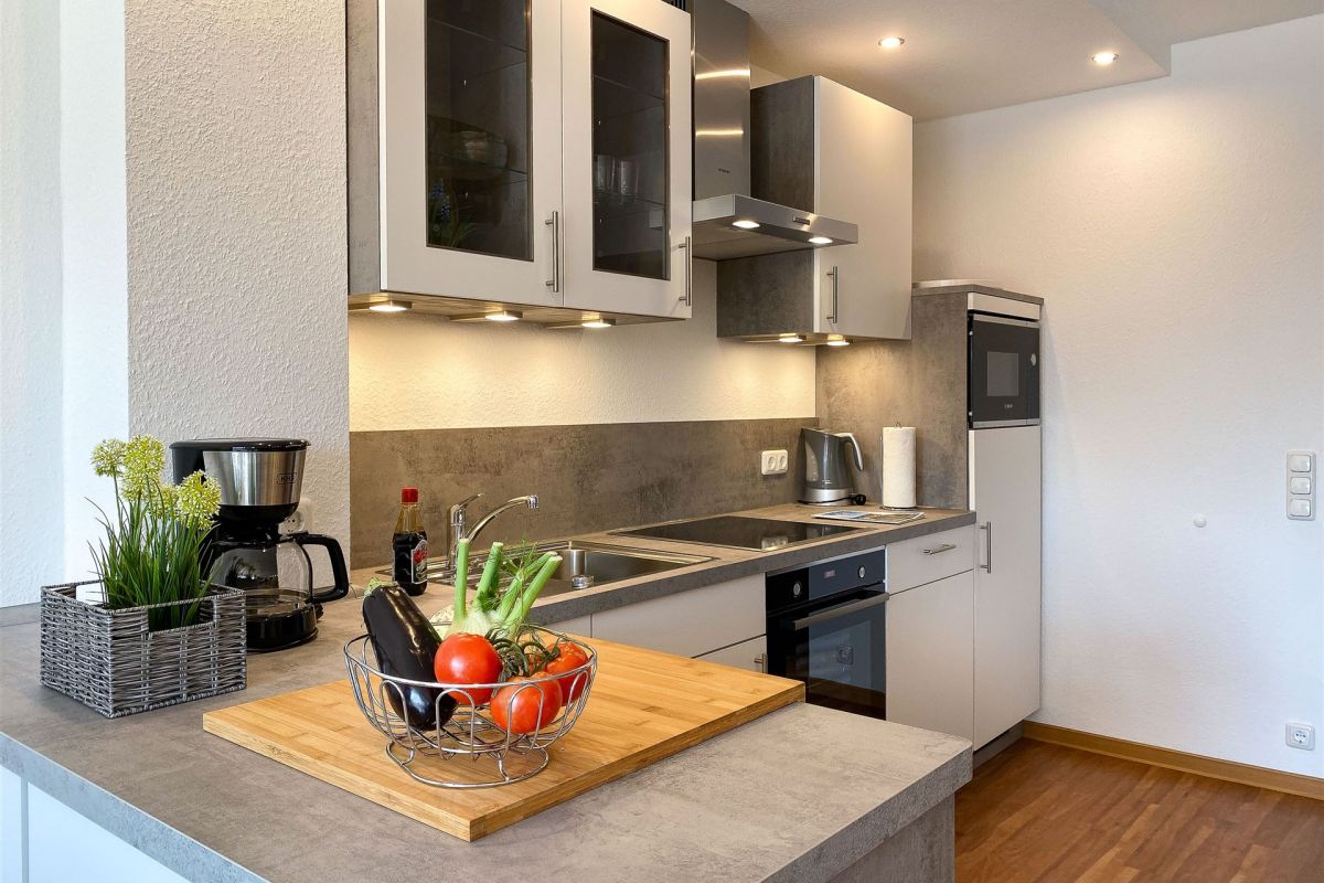 Küchentresen mit großzügigem Arbeitsbereich: Die Komfort-Küche im Apartment W6 bietet viel Platz für gemeinsames Kochen im Urlaub 