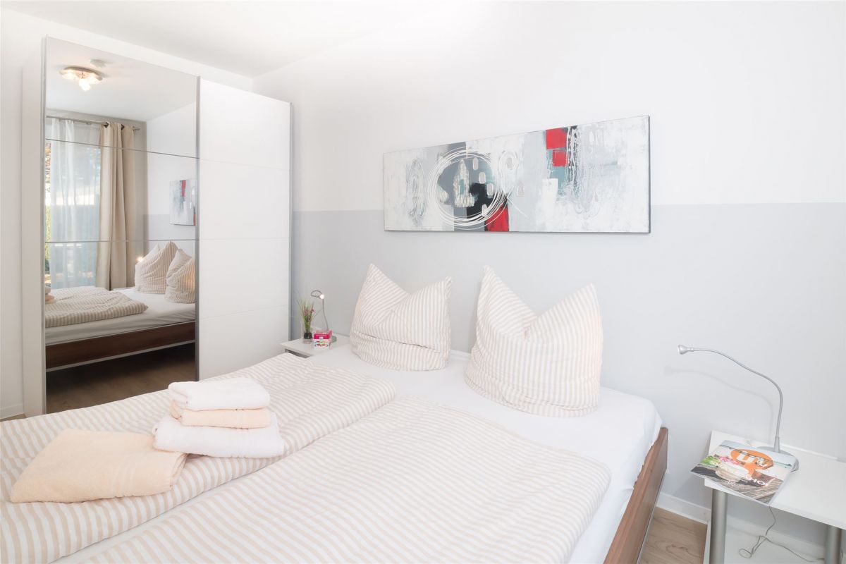 Doppelbett, Spiegelschrank und eine modern gestaltete Rückwand verleihen diesem SChlafraum mit Terrassen-Austritt Charme (K1)