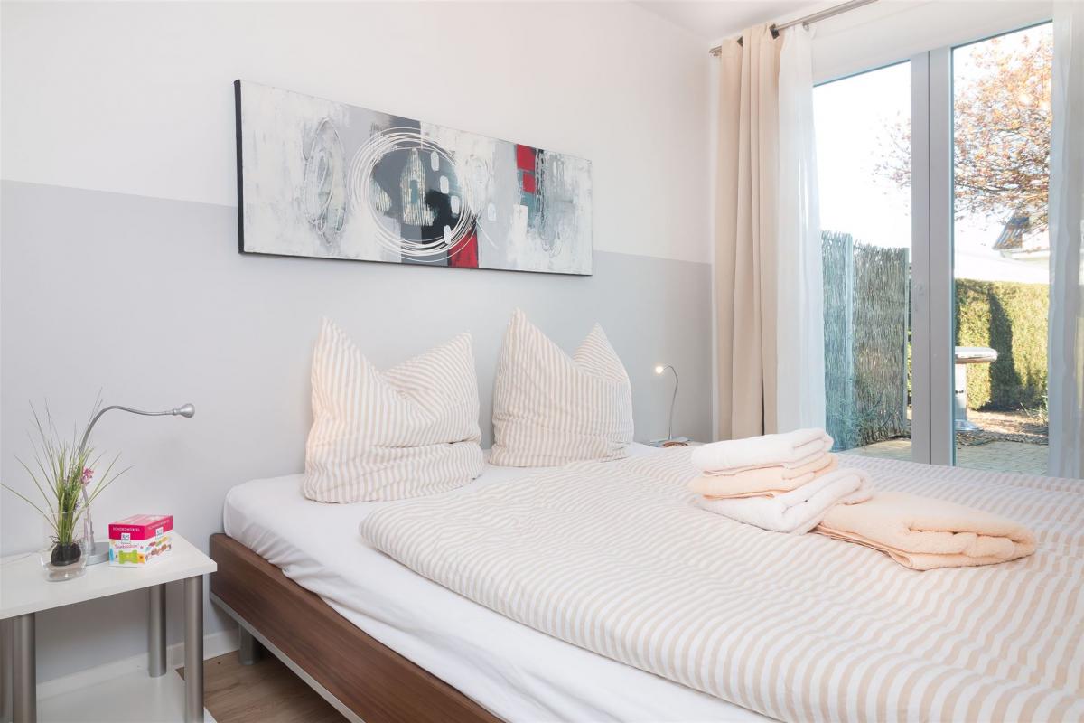 Schlafraum mit Doppelbett und Austritt auf Terrasse des Komfort-Apartments K1