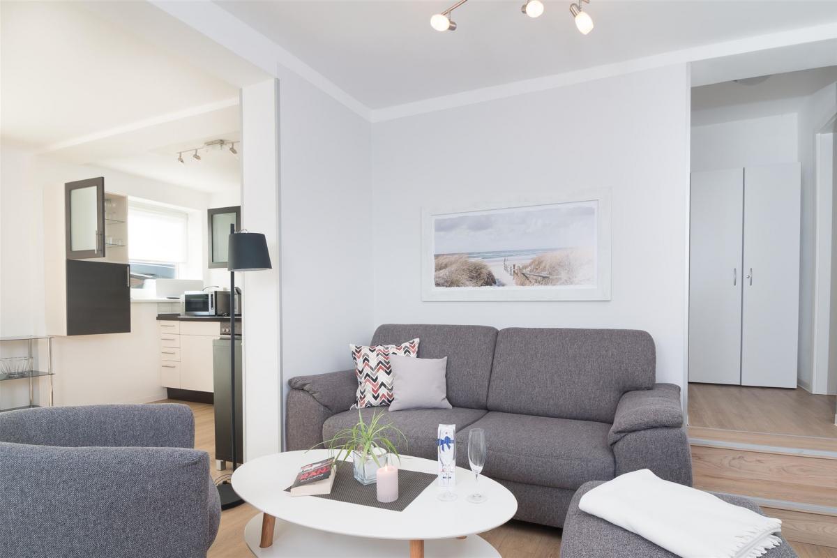 Moderner, heller Wohnraum mit grauer Sitzgruppe im Komfort-Apartment K1