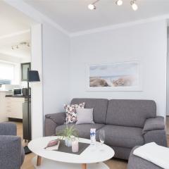 Moderner, heller Wohnraum mit grauer Sitzgruppe im Komfort-Apartment K1