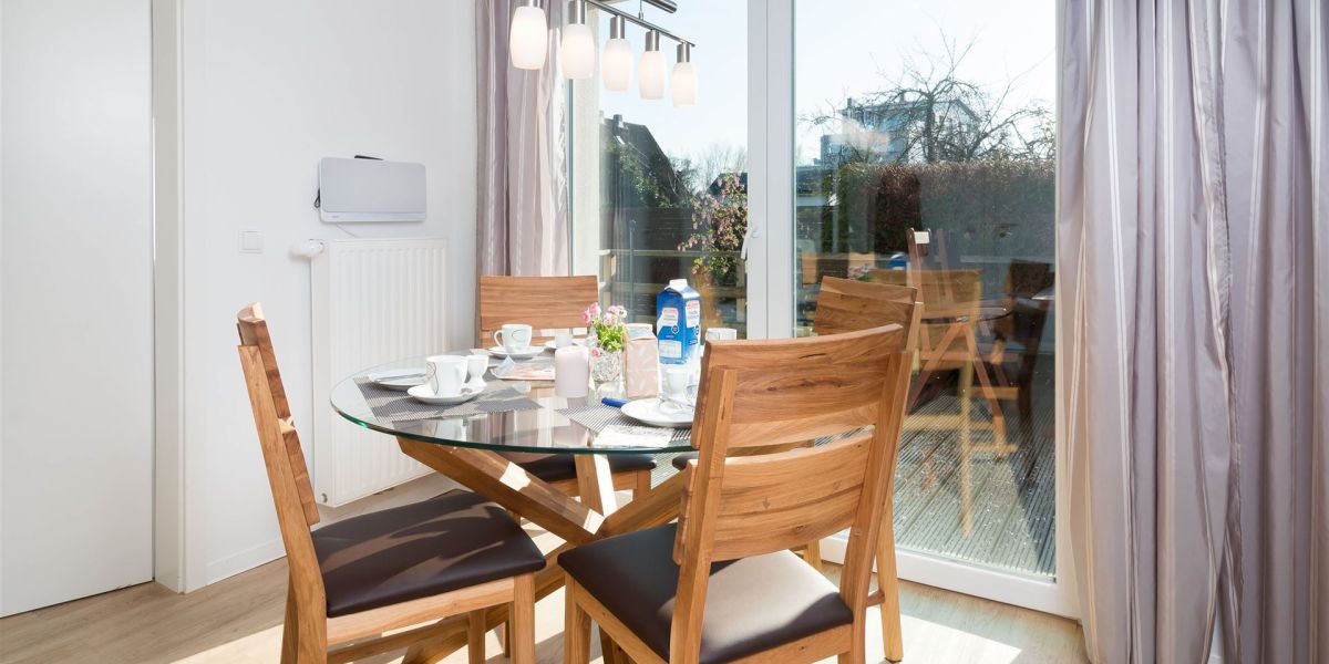 Essplatz mit rundem Glastisch und vier Holzstühlen im Strandhaus-Bungalow K2